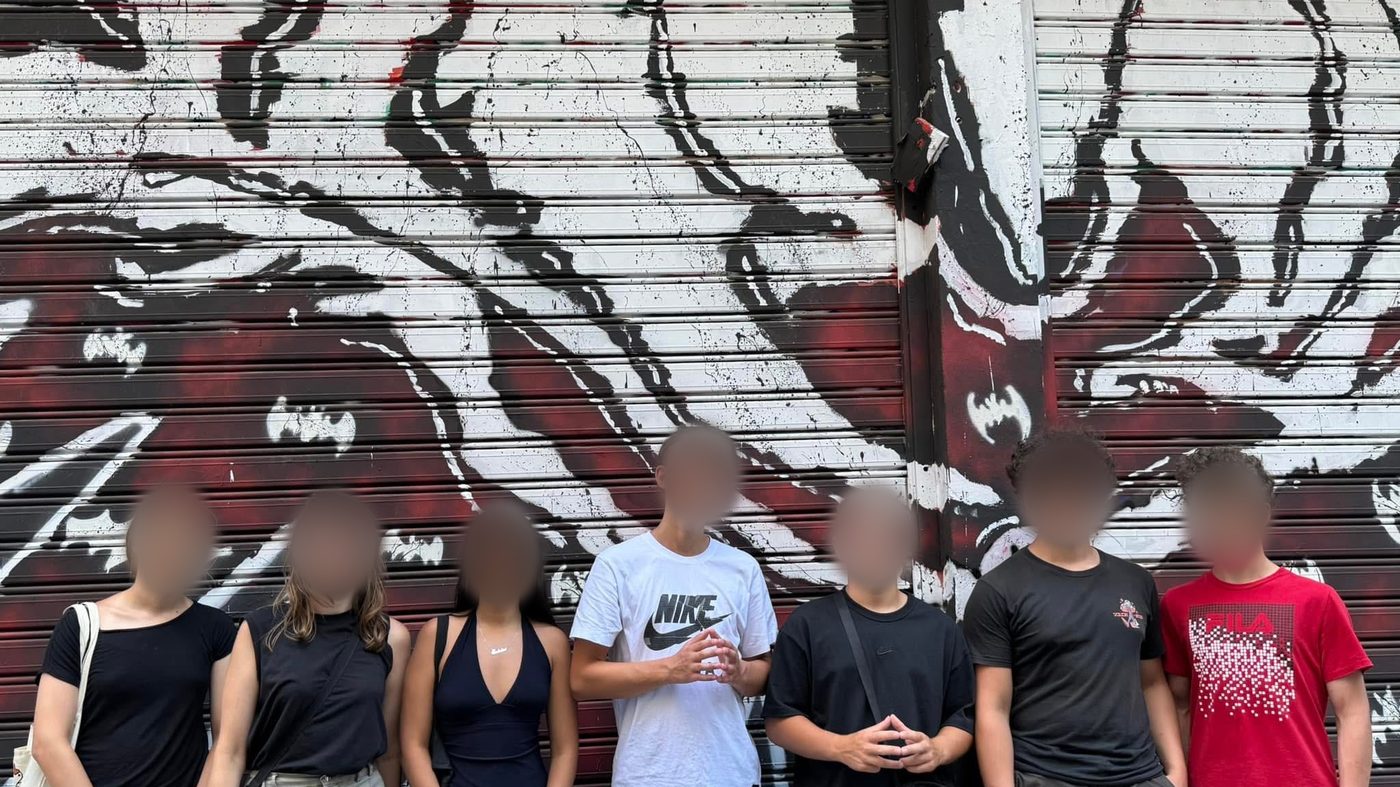 Μαθητές μπροστά σε έναν τοίχο με γκράφιτι στην Αθήνα