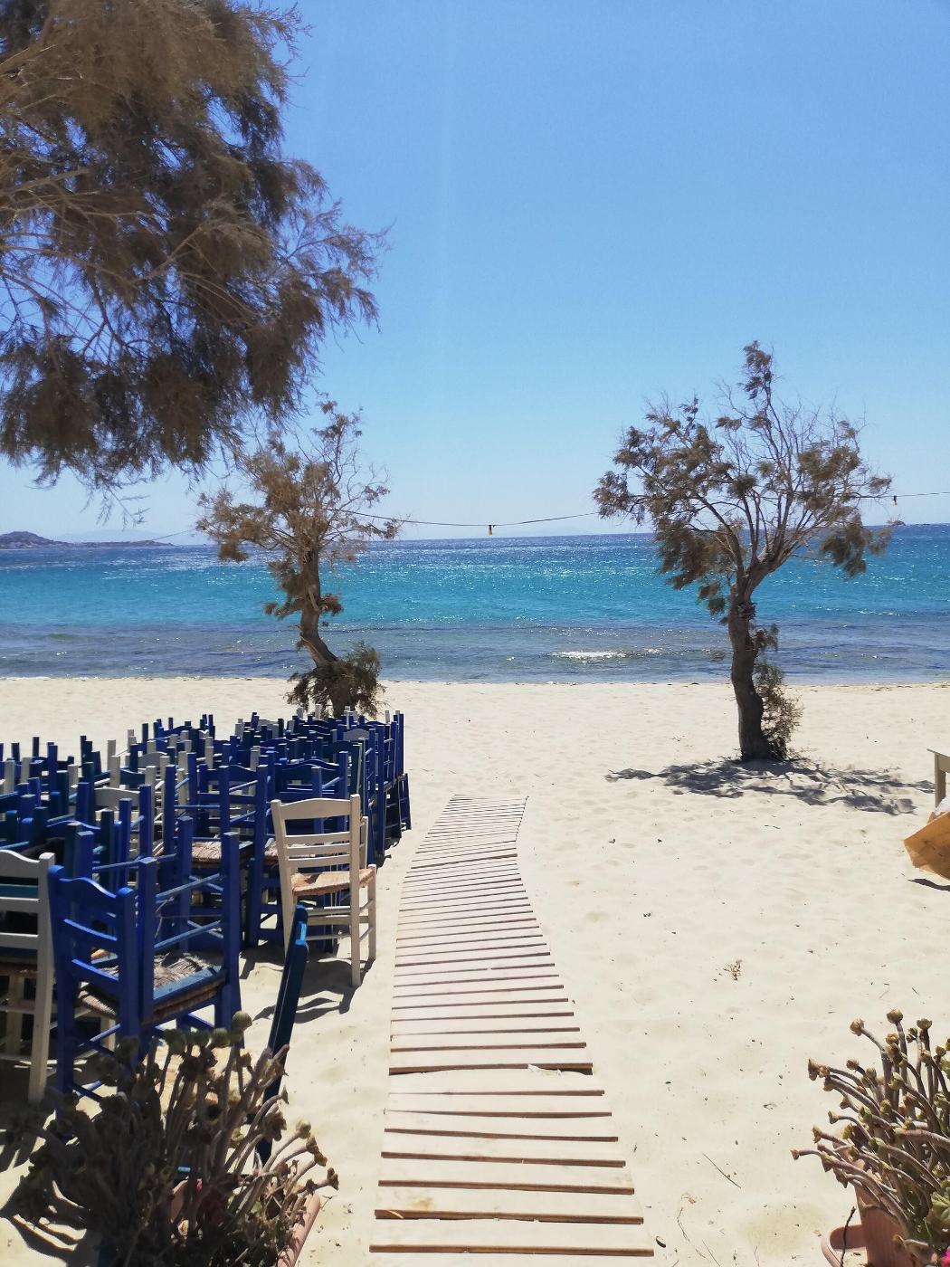 Το ξύλινο διάδρομο προς την παραλία της Πλάκας, δίπλα στα τραπέζια της ταβέρνας