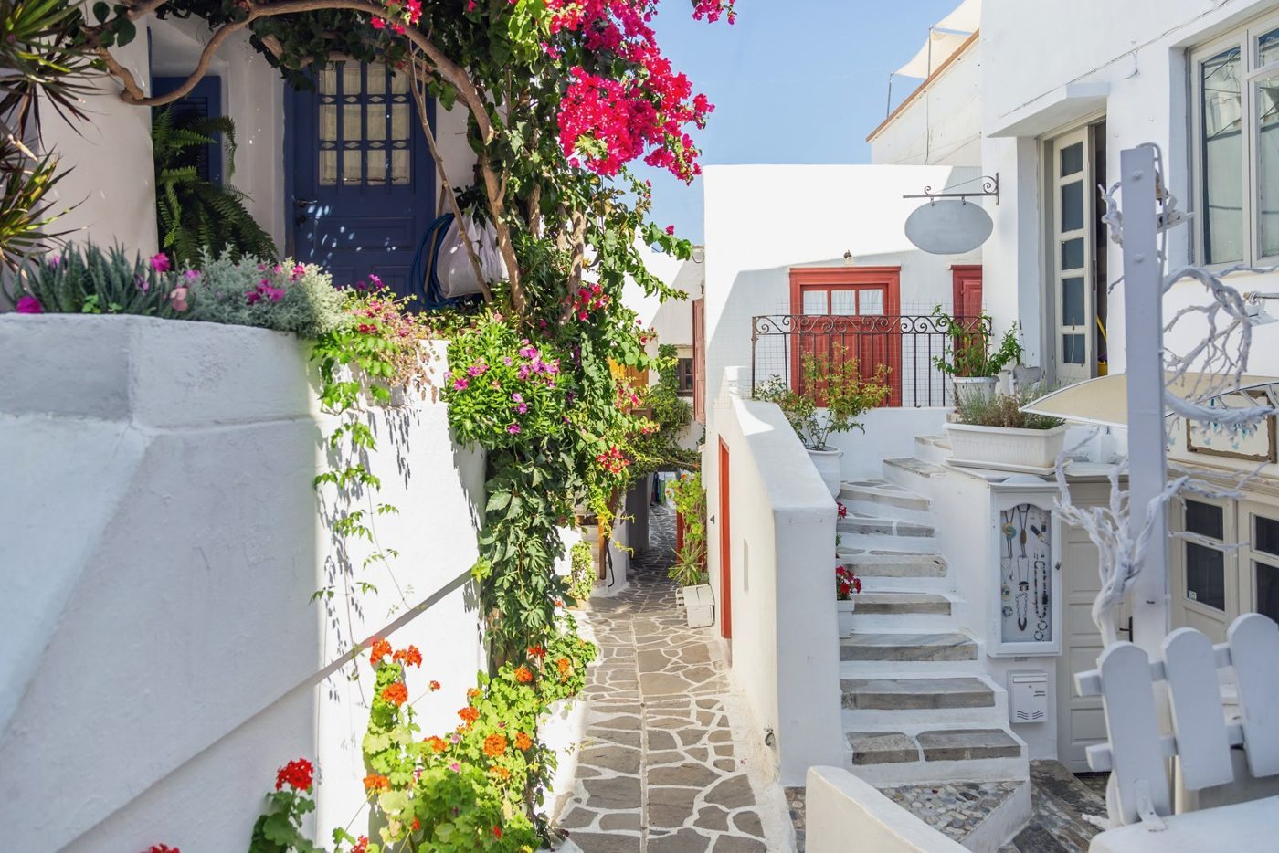 Βουκαμβίλιες και ασβεστωμένα σπίτια σε πλακόστρωτο σοκάκι της Χώρας