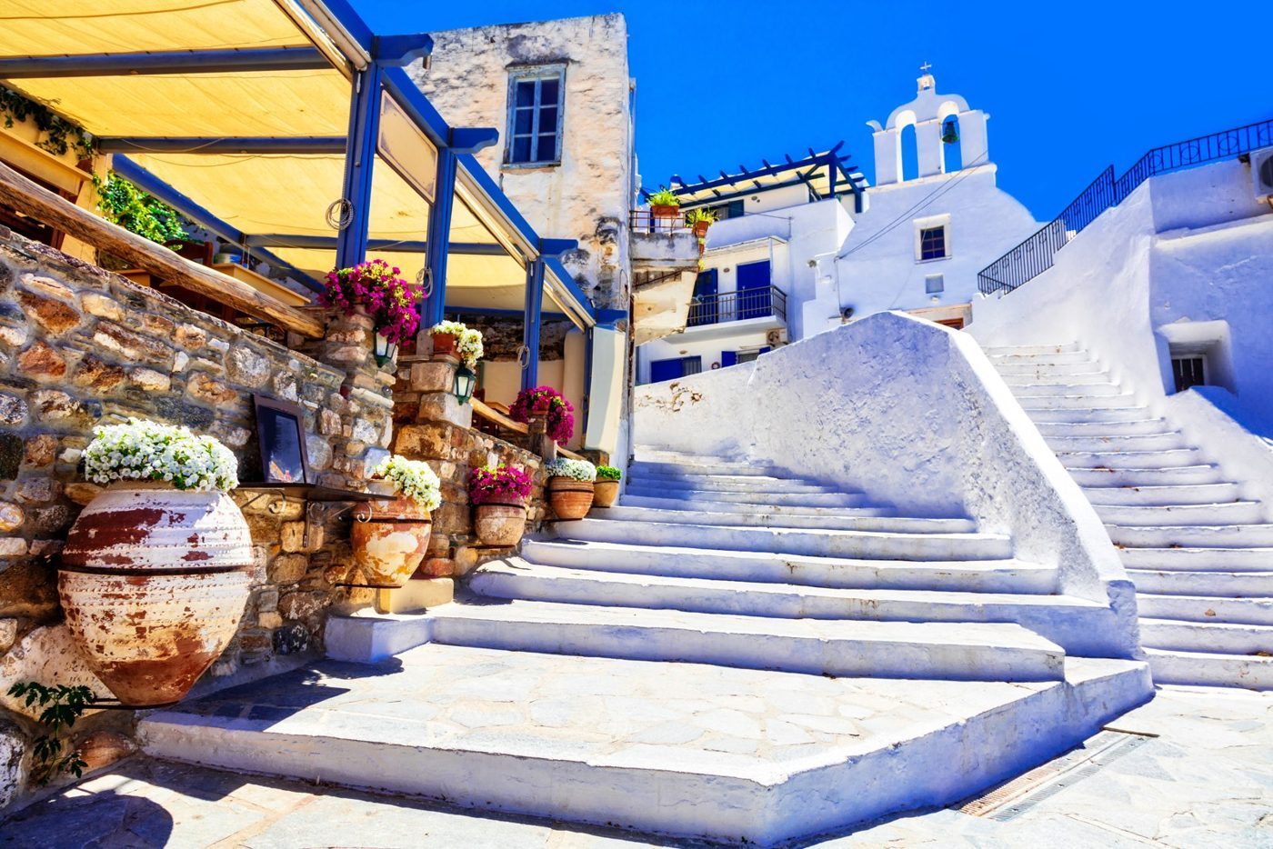 Ασβεστωμένα σκαλιά, λουλούδια και ένα γαλάζιο εκκλησάκι σε χωριό της Νάξου